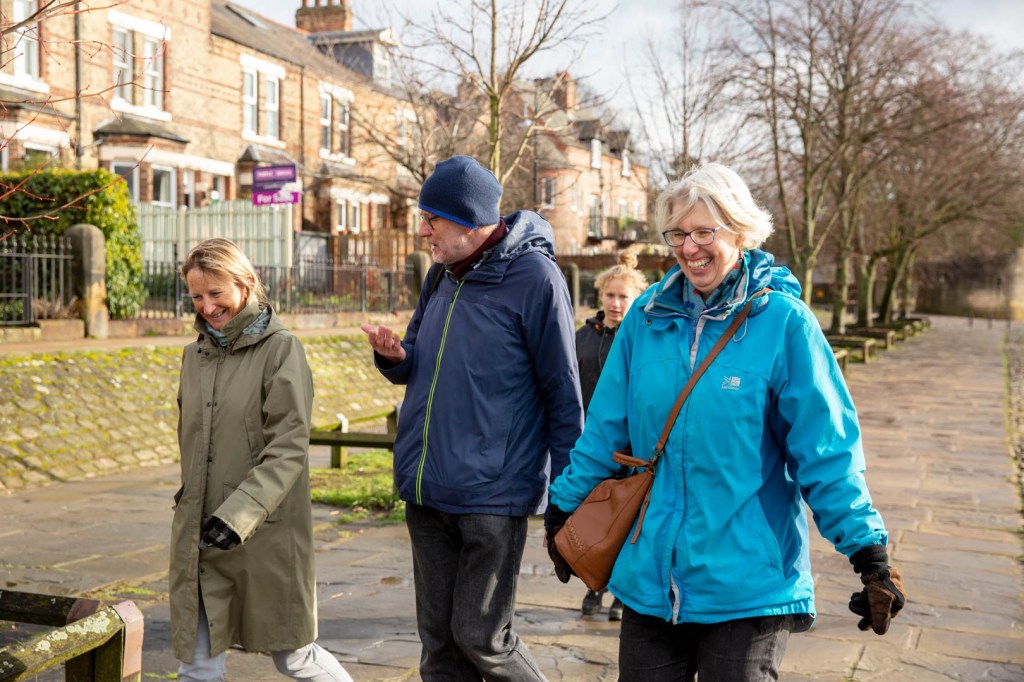 Three people walking and laughing