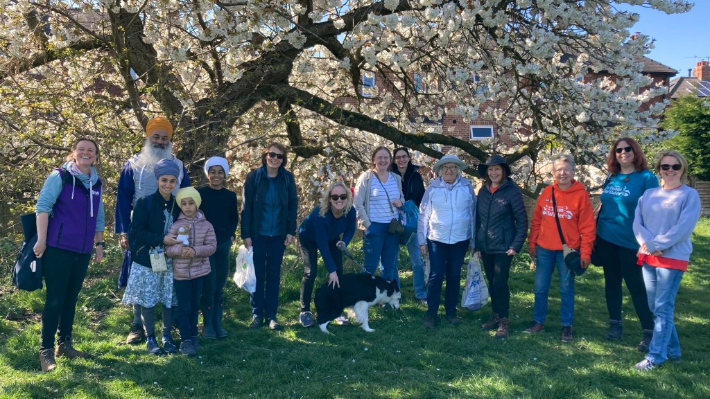 Group stand together in front of Cherry Tree in bloom