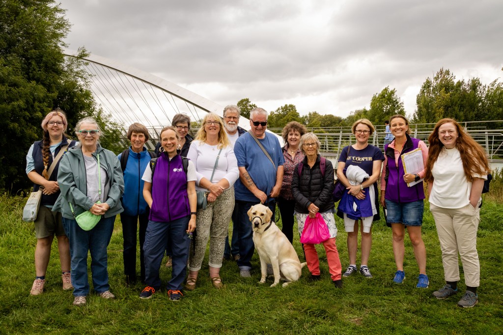 Group stand together in front of the Millennium Bridge